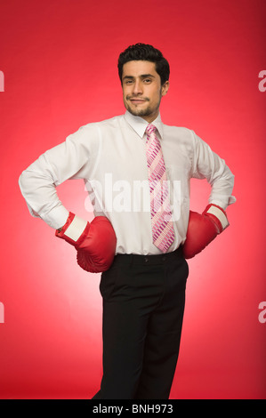 Porträt eines Geschäftsmannes tragen Boxhandschuhe und stehen mit angewinkelten Armen Stockfoto