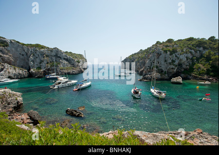 Segelboote vor Anker in der verschlafenen Bucht von Calas Buchten auf der spanischen Insel Menorca Stockfoto