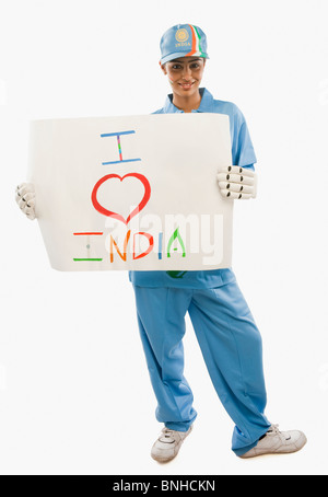 Frau in Cricket Uniform hält ein Schild mit Text ich liebe Indien darauf geschrieben Stockfoto