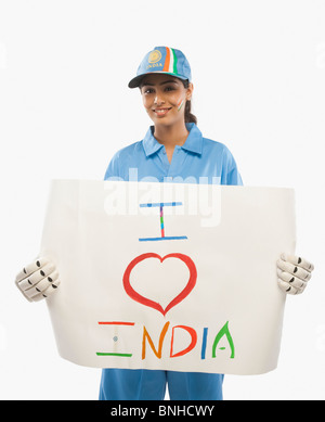 Frau in Cricket Uniform hält ein Schild mit Text ich liebe Indien darauf geschrieben Stockfoto