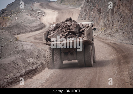 Große earth Mover dump Ziehen-Lkw im Steinbruch bergauf langsam Rubrik mit volle Ladung Rock Stockfoto