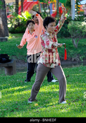 Frau, die Durchführung von Tai Chi Übungen mit einem großen Schwert im Lumpini Park, Bangkok Stockfoto