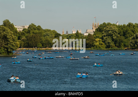 Serpentine Lake, Hyde Park im Zentrum von London, Großbritannien. Leute, die sich in Tretbootverleih Vergnügen. Houses of Parliament im Hintergrund. 2010 2016 HOMER SYKES Stockfoto