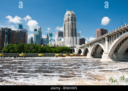 Ein Blick auf die Skyline der Minneapolis vom Westufer des Mississippi River. Im Vordergrund sieht man den Mississippi River. Stockfoto