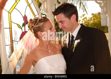 Braut und Bräutigam Lächeln einander an. Stockfoto