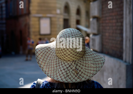 Italien. Toskana. Model Release Frau trägt einen Strohhut in San Gimignano toskanische Hügel obere Stadt mit Türmen. Stockfoto
