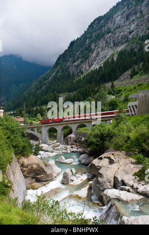 Schweiz. Reisen Sie mit dem Zug in der Schweiz. Die Matterhorn-Gotthard-Bahn Zug laufen Richtung Norden über die Reuss in Richtung Alt Stockfoto