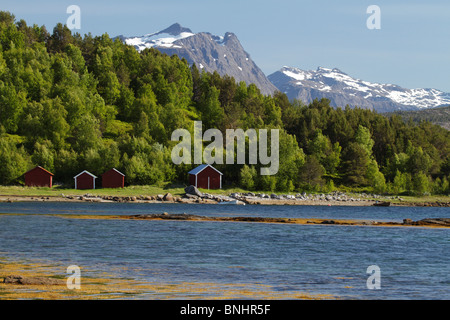 Bootshäuser am Hamaroy, Norwegen. Schneebedeckte Berge in der Ferne zu sehen. Stockfoto