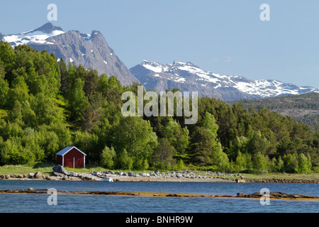 Bootshäuser am Hamaroy, Norwegen. Schneebedeckte Berge in der Ferne zu sehen. Stockfoto