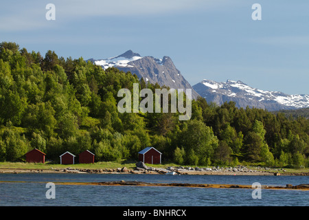 Bootshäuser am Hamaroy, Norwegen. Schneebedeckte Berge in der Ferne zu sehen. Stockfoto