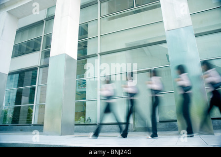 abstrakte Bewegungsunschärfe von Menschen zu Fuß durch ein Bürogebäude Stockfoto
