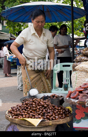 Frau am Markt in Myanmar (Burma) Verkauf von gerösteten Kastanien Stockfoto