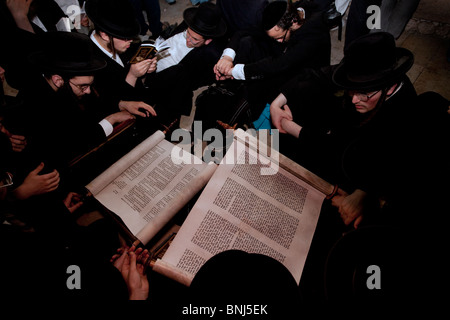 Ultra-orthodoxe Juden lesen aus einer Tora-Schriftrolle das biblische Buch der Klage am jährlichen Fasttag von Tisha Beav in der Klagemauer Ostjerusalem Israel Stockfoto