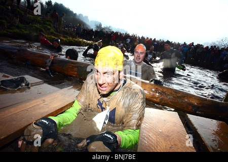 Ein Konkurrent Zahnspange selbst für die Unterwasser-Tunnel auf der jährlichen Winter Tough Guy in Perton, Staffordshire. Stockfoto
