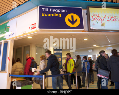 Passagiere stehen in einer Warteschlange im Abflugbereich im Flughafen Kiruna. Stockfoto