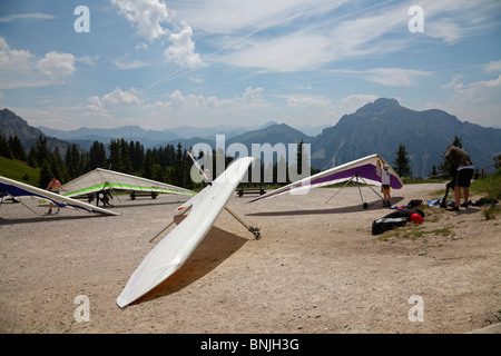 Hängegleiter bereiten ihre Flugzeuge vor ihrem Abflug vom Gipfel des Tegelberg, Scwangau, Bavaria, Germany. Stockfoto