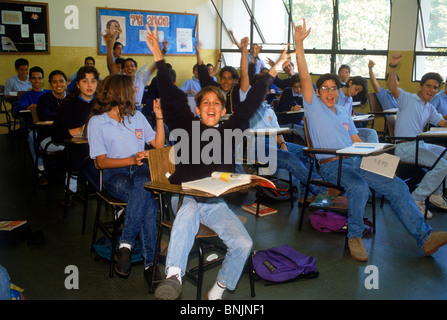 Typische Klassenzimmer Grundschüler mit glücklichen Gesichtern und Arme nach oben in Caracas, Venezuela Stockfoto