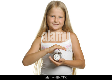 Das Mädchen hält einen Wecker in Händen. Es ist isoliert auf weißem Hintergrund Stockfoto