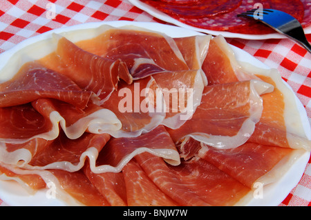 Jamon Serrano (Schinken) auf einem weißen Teller mit Salami nach hinten, Andalusien, Spanien-Westeuropa. Stockfoto