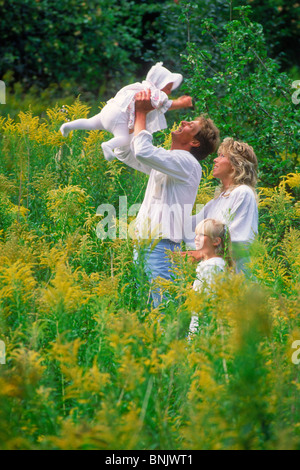 Vierköpfige Familie im Gebiet der wilden gelben Blüten in Schweden Stockfoto