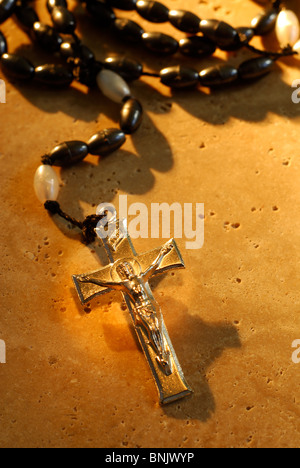 Traditionelle Metall Kruzifix Rosenkränze Perlen auf einem Stein Hintergrund Stockfoto
