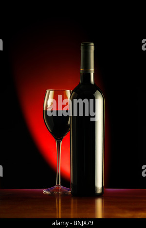 Wein und Glas gegen einen schwarzen Hintergrund mit rotem Licht Stockfoto