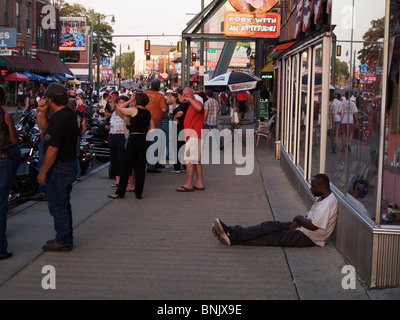 Mann sitzt auf dem Bürgersteig. Bike Night, Beale Street. Memphis, Tennessee Stockfoto