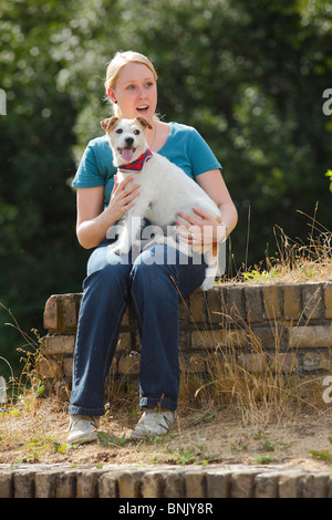 Frau mit Parson Russell Terrier auf Schoß / Parson Jack Russell Terrier Stockfoto