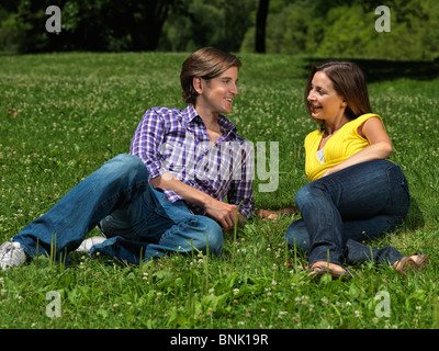 Junge glückliche Paar in den frühen Dreißigern liegen auf dem Rasen in einem park Stockfoto