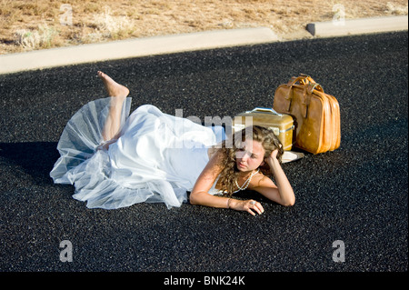 Eine Braut wird gekickt an den Straßenrand und ganz allein auf einer abgelegenen Straße. Stockfoto