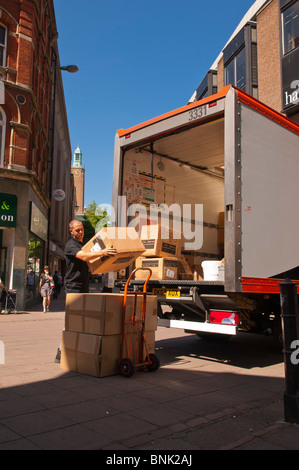 Ein Arbeiter packt Pakete von der Rückseite des TNT Kurier van LKW Fahrzeug in Norwich, Norfolk, England, Großbritannien, Uk Stockfoto