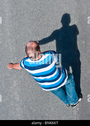 Draufsicht des Mannes / Schatten entlang Straße - Frankreich. Stockfoto