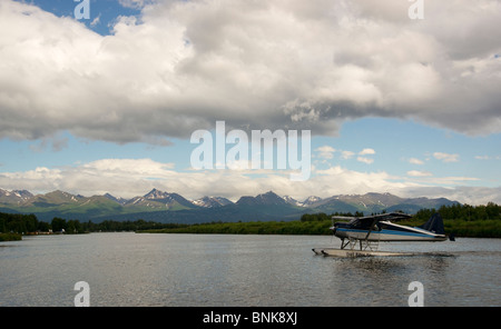 Ponton-Flugzeug fliegt von Lake Hood in Anchorage, umrahmt von den Chugach Mountains Stockfoto