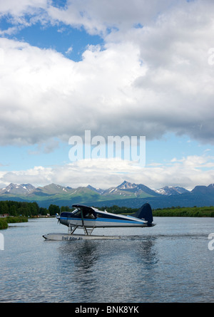 Ponton-Flugzeug fliegt von Lake Hood in Anchorage, umrahmt von den Chugach Mountains Stockfoto