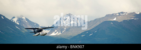 Ponton-Flugzeug fliegt von Lake Hood in Anchorage, umrahmt von den Chugach Mountains Stockfoto