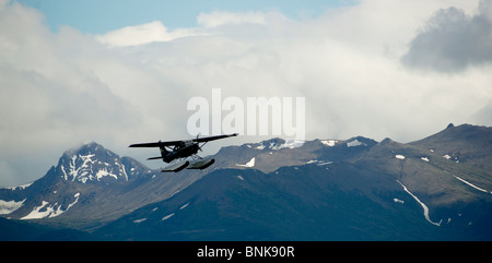 Ponton-Flugzeug fliegt von Lake Hood in Anchorage, umrahmt von den Chugach Mountains Stockfoto