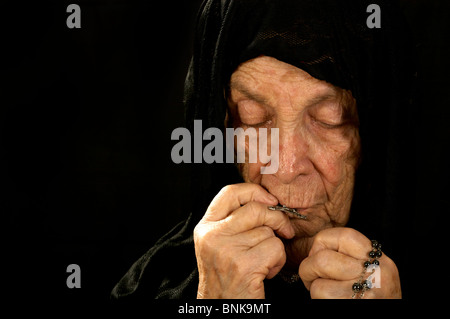 Katholische alte Frau tief im Gebet tragen einen schwarzen Schleier Stockfoto