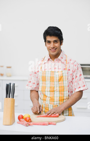 Mann Hacken Gemüse in der Küche Stockfoto