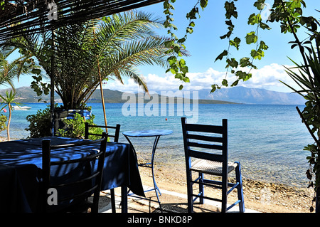 Ein typisch rustikalen griechisches Restaurant mit blau lackierten Tischen und Stühlen im Schatten positioniert. Stockfoto