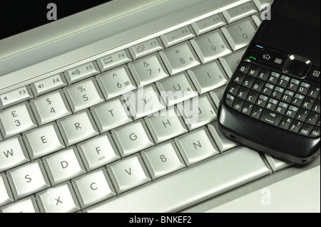 Schließen Sie herauf Bild von einem Laptop-Computer-Tastatur und eine moderne mobile Zelle Telefon Stockfoto