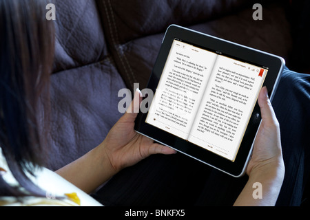 Eine Frau Entspannung beim Lesen von "Pride and Prejudice" aus einer iPad app, iBook Stockfoto