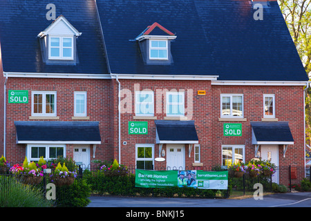 Reihe von neuen Barratt Häuser auf einer Wohnsiedlung in Hampshire, Südostengland, jeweils mit einem verkauften Schild an der Wand. Stockfoto