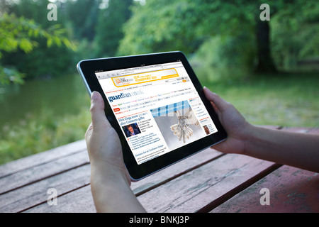 Eine Frau liest die Online-Zeitung Guardian aus einem iPad in der Outdoor-park Stockfoto