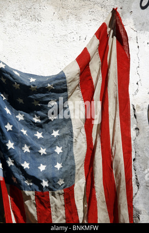 eine alte amerikanische Flagge an Wand draußen in der Sonne hängen Stockfoto