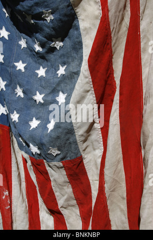 eine alte amerikanische Flagge an Wand draußen in der Sonne hängen Stockfoto