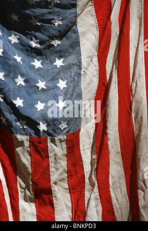 eine alte amerikanische Flagge an Wand draußen in der Sonne hängen Stockfoto