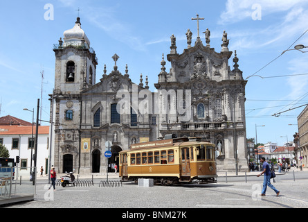 Alte Straßenbahn vor einer Kirche in Porto, Portugal Stockfoto