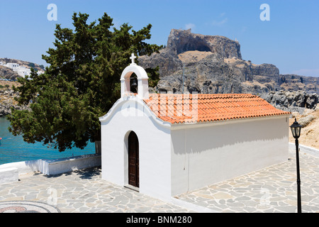 Weiß getünchte Kapelle in St. Pauls Bay mit der Akropolis hinter, Lindos, Rhodos, Griechenland Stockfoto