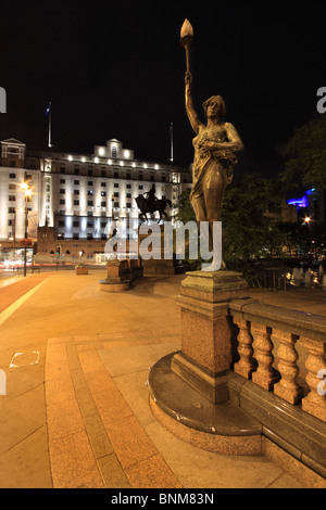 Eine nächtliche Ansicht City Square in Leeds, West Yorkshire, eine Statue mit The Queens Hotel im Hintergrund Stockfoto