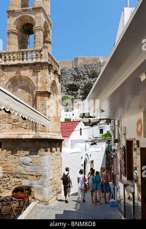 Geschäfte in der Ortsmitte von Lindos mit der Akropolis auf dem Hügel hinter, Rhodos, Griechenland Stockfoto